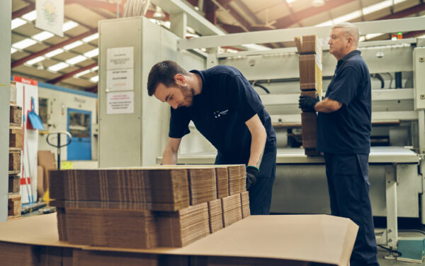 Male McLaren worker handling corrugated cardboard packaging